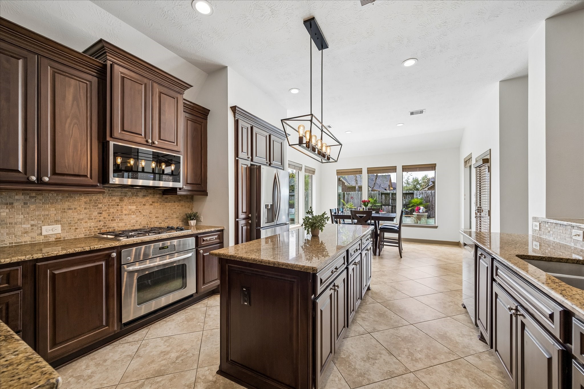 28211 Rippling Brook Lane Fulshear, TX 77441 - Photo 11 of 45 HEART OF THE HOME: This open-concept kitchen anchors the space with expansive sightlines, a large center island, and seamless flow into the living and dining areas.