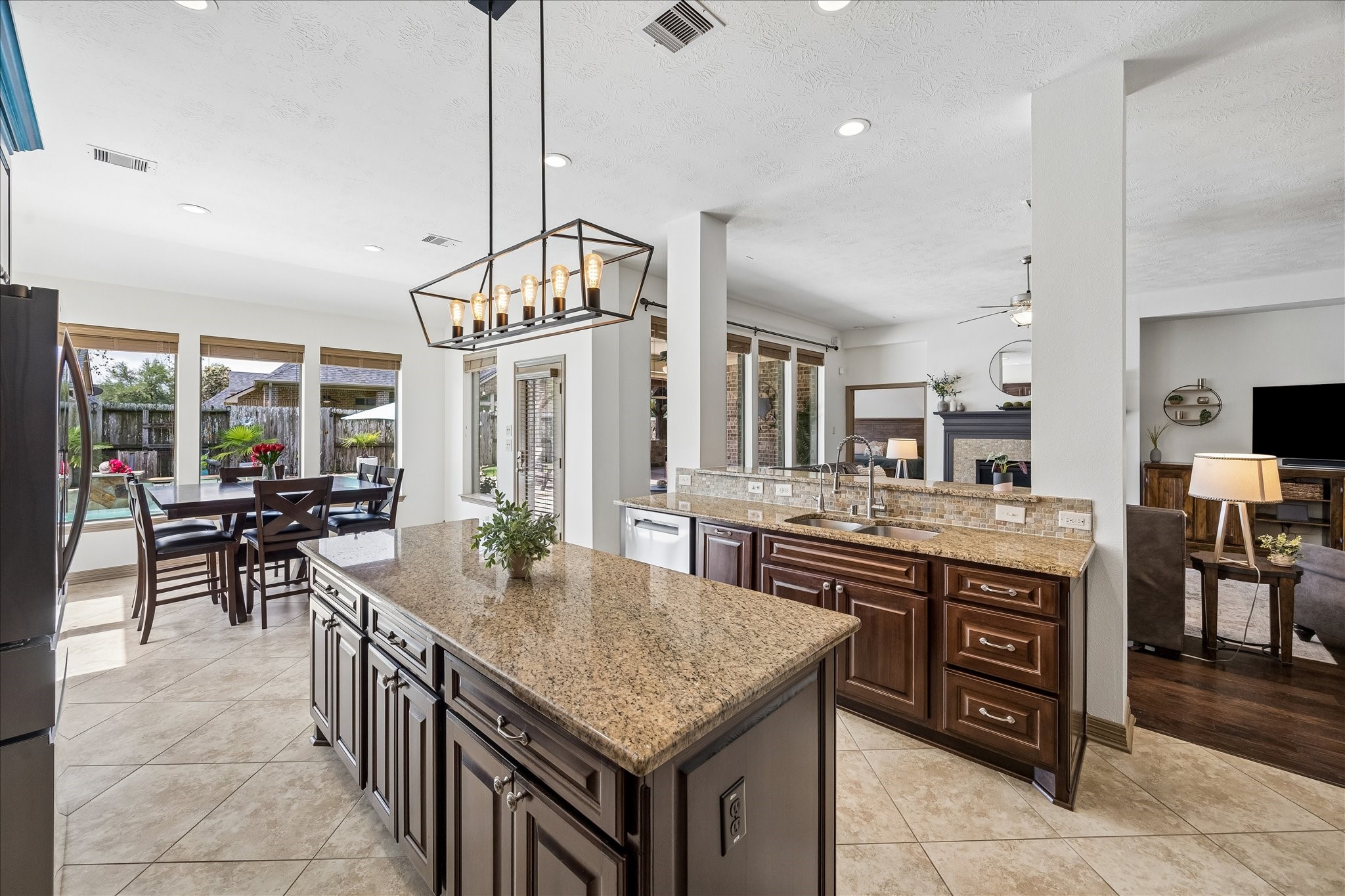 28211 Rippling Brook Lane Fulshear, TX 77441 - Photo 9 of 45 ELEVATED FINISHES: Granite countertops, a designer backsplash, stainless steel appliances, and rich wood cabinetry with crown molding create a timeless, functional design.