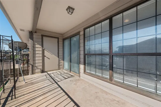a bedroom with a balcony and large window
