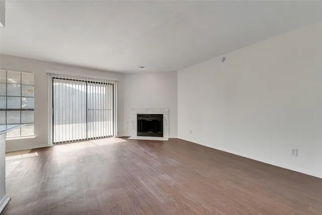 an empty room with wooden floor and fireplace