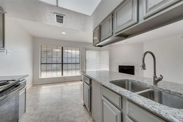 a kitchen with stainless steel appliances granite countertop a sink and a stove