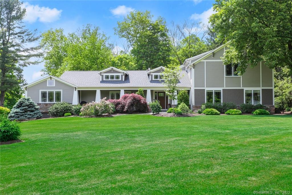 a front view of a house with a yard and green space