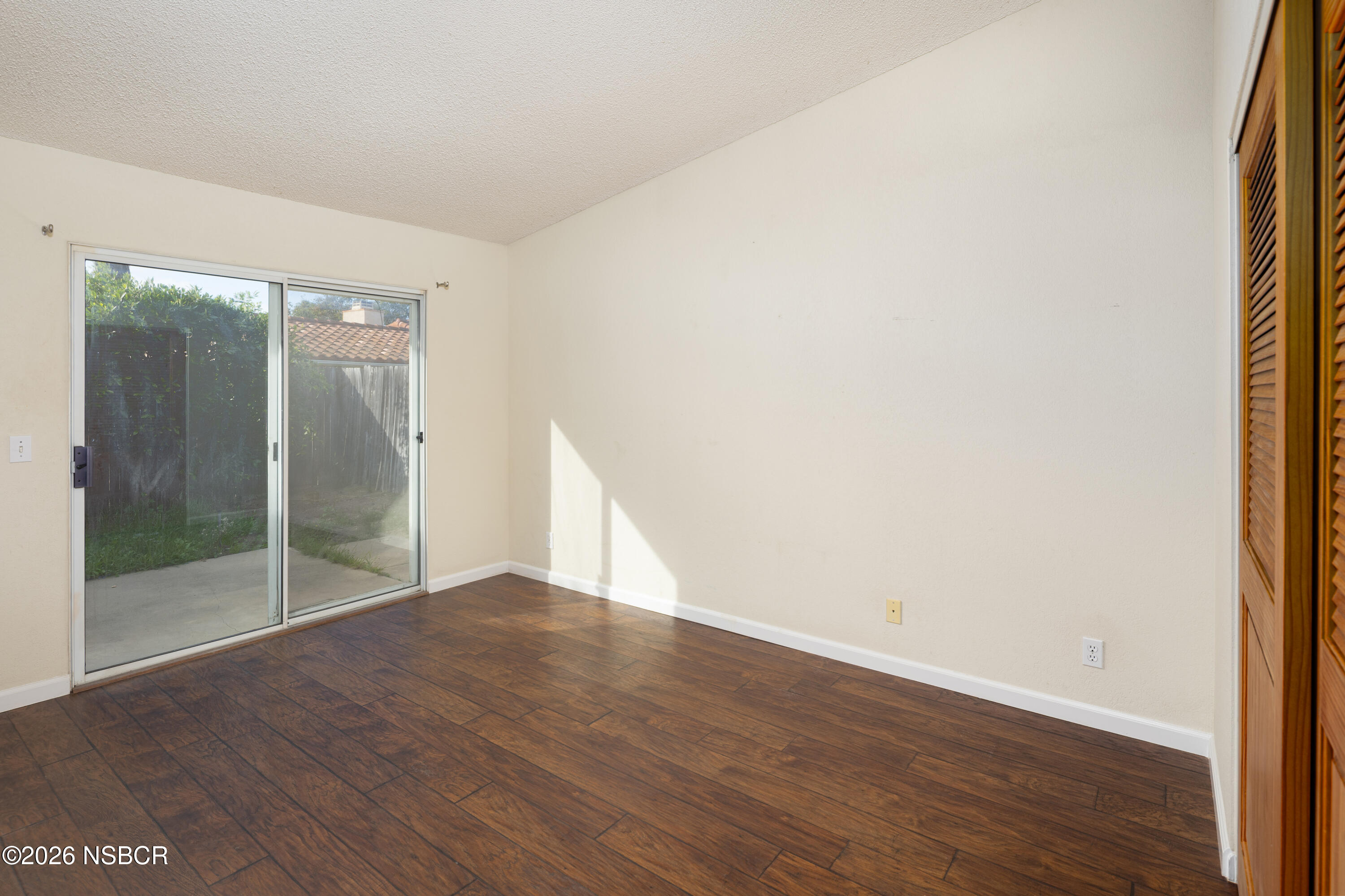 545 Santa Cruz Court Santa Maria, CA 93455 - Photo 15 of 28 an empty room with wooden floor and sliding door