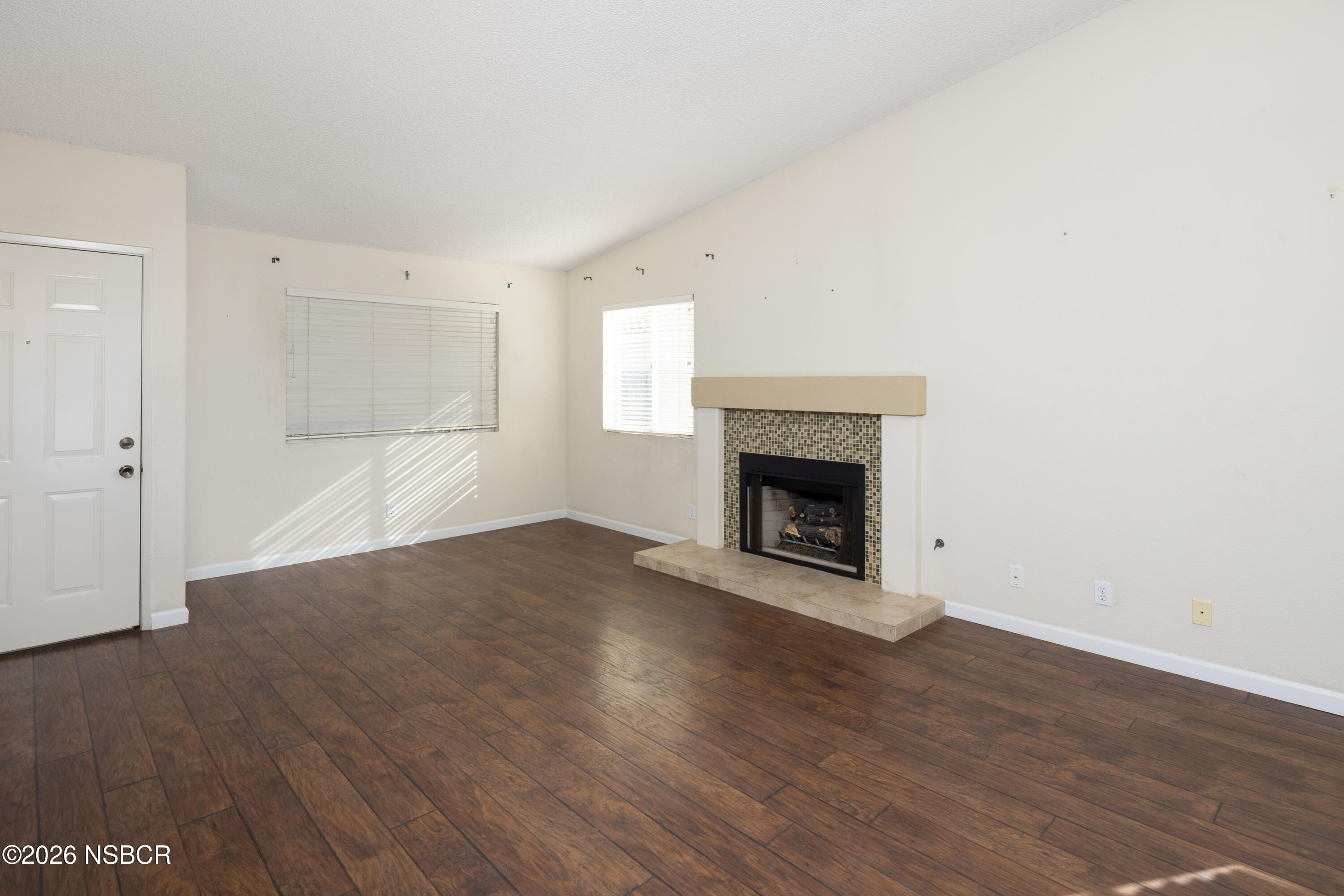 545 Santa Cruz Court Santa Maria, CA 93455 - Photo 4 of 28 a view of an empty room with wooden floor fireplace and a window
