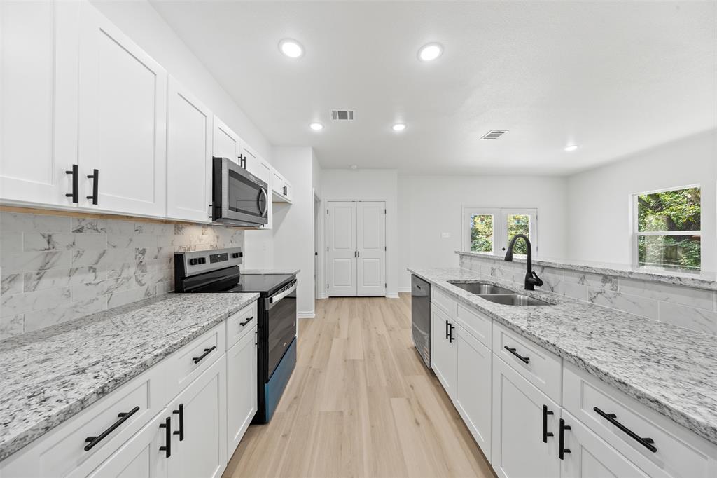 506 2nd Street Moody, TX 76557 - Photo 16 of 40 a large kitchen with stainless steel appliances granite countertop a sink dishwasher a stove and a granite counter tops