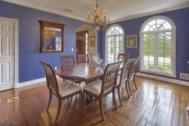 a view of a dining room with furniture a chandelier and wooden floor