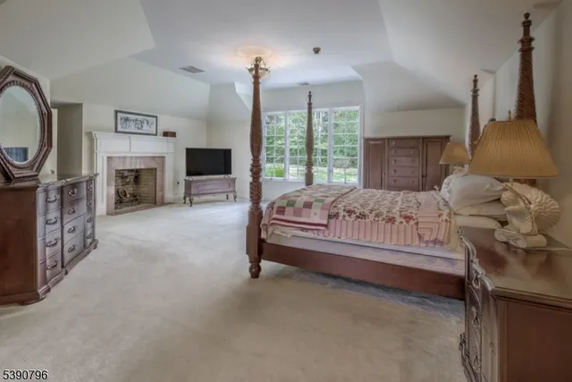 a bedroom with a bed a fireplace and a chandelier