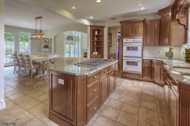 a kitchen with stainless steel appliances granite countertop a stove a sink a oven and a refrigerator