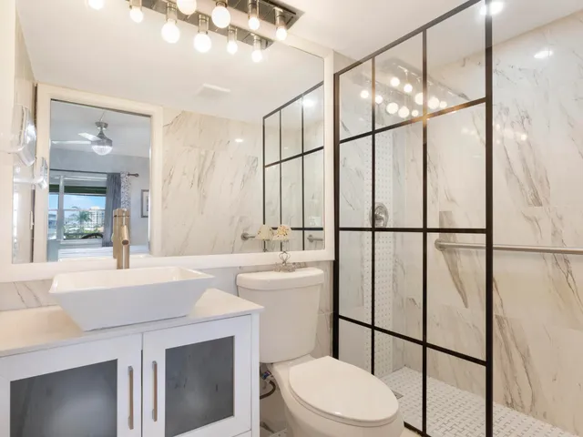 a bathroom with a sink a toilet and shower