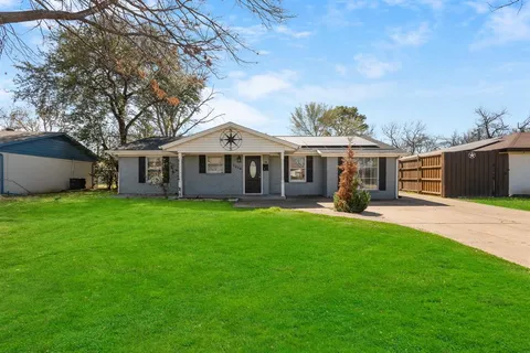 a front view of a house with a garden and yard