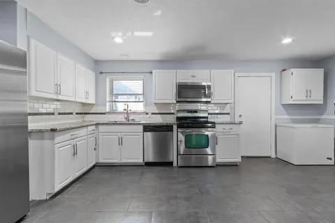 a kitchen with sink a microwave and cabinets