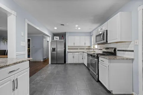 a kitchen with stainless steel appliances granite countertop a refrigerator sink and cabinets