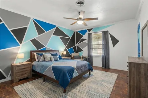 a bedroom with a bed wooden floor and ceiling fan