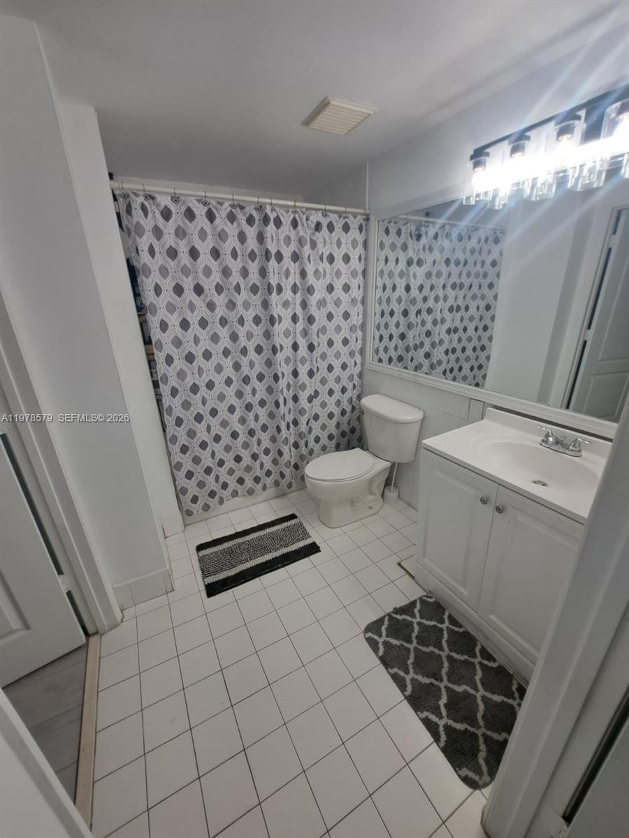 5077 Northwest 7th Street, Unit 912 Miami, FL 33126 - Photo 9 of 28 a bathroom with a toilet and a shower