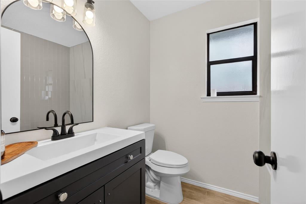 509 Brookside Court Burleson, TX 76028 - Photo 13 of 18 a bathroom with a sink a toilet and mirror