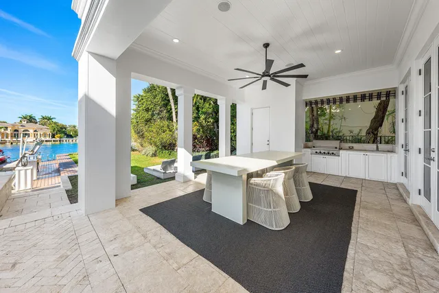 a large white bed sitting in a room next to a window with a chandelier