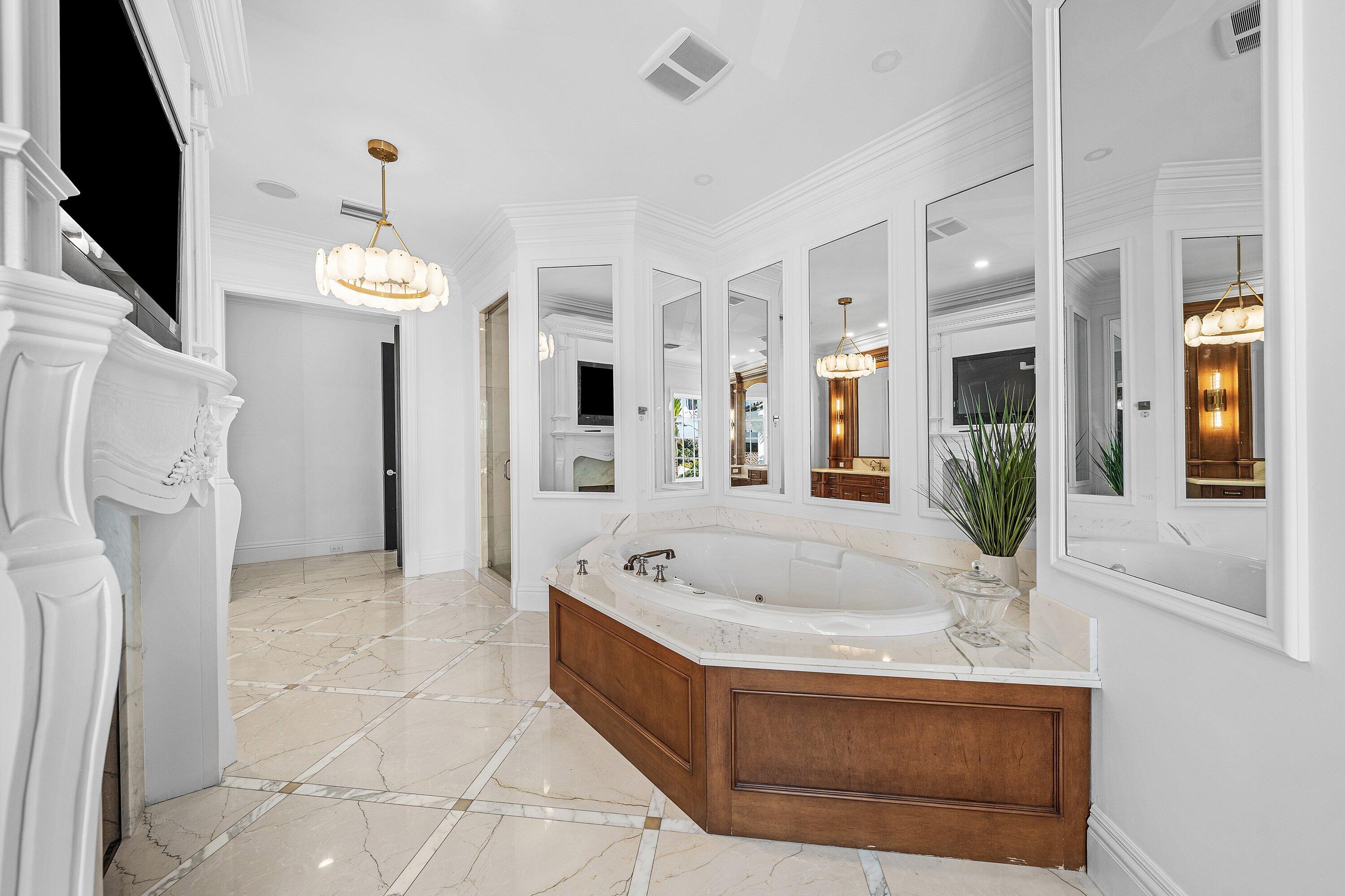 485 Northeast Spanish Trail Boca Raton, FL 33432 - Photo 56 of 76 a spacious bathroom with a tub sink and mirror