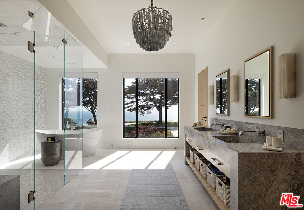 4145 Creciente Drive Santa Barbara, CA 93110 - Photo 26 of 57 a bathroom with a granite countertop sink a large mirror and a bathtub