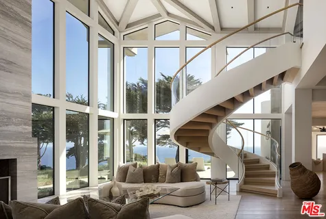 a living room with furniture a fireplace and a large window