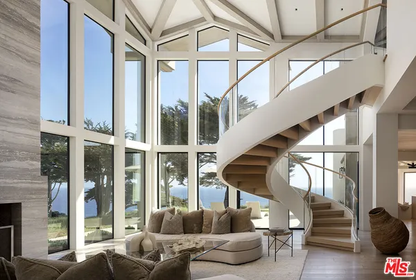 a living room with furniture a fireplace and a large window