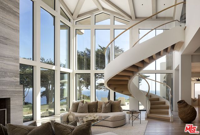 a living room with furniture a fireplace and a large window