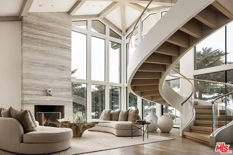 a living room with furniture ceiling fan and a floor to ceiling window