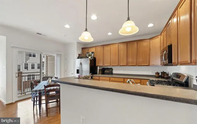 a living room with furniture kitchen view and a chandelier