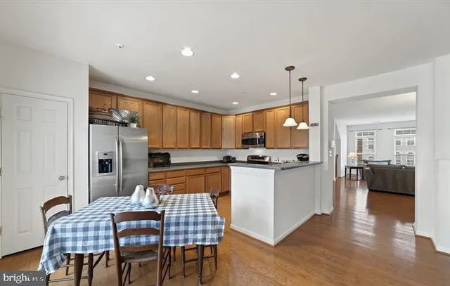 a kitchen with kitchen island granite countertop a sink stainless steel appliances and cabinets