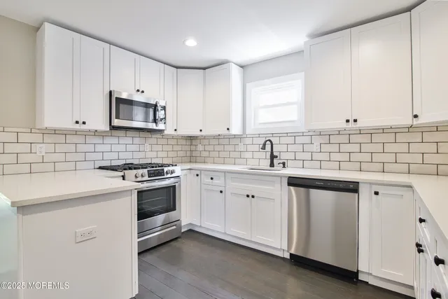 a kitchen with cabinets appliances a sink and a counter top space