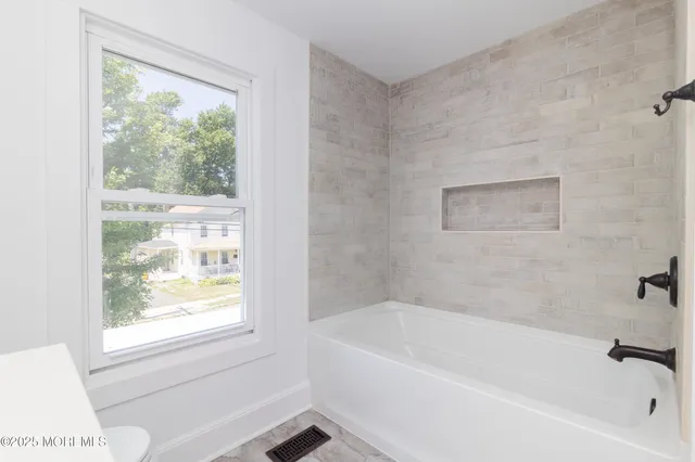 a white bath tub sitting next to a window