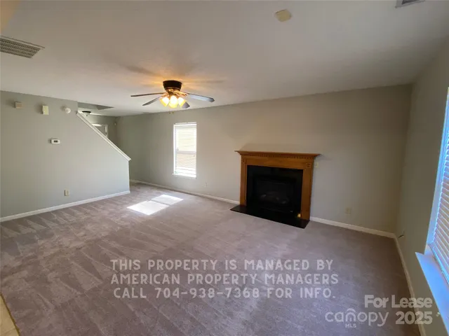 a view of an empty room with window and fireplace