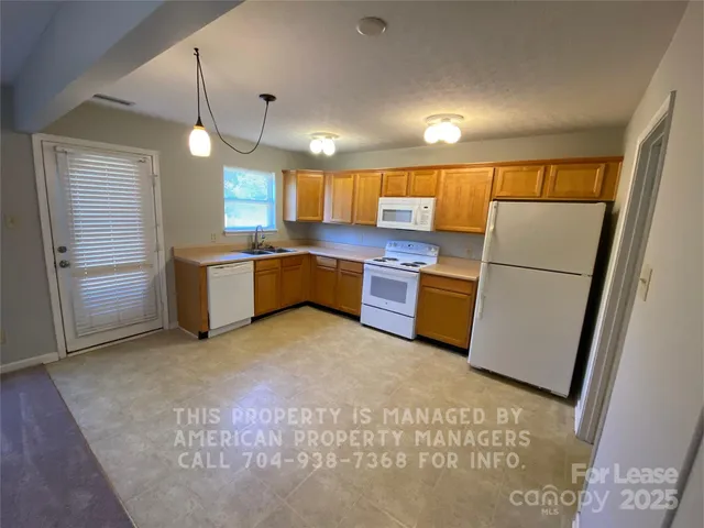 a kitchen with stainless steel appliances a refrigerator and a more cabinets