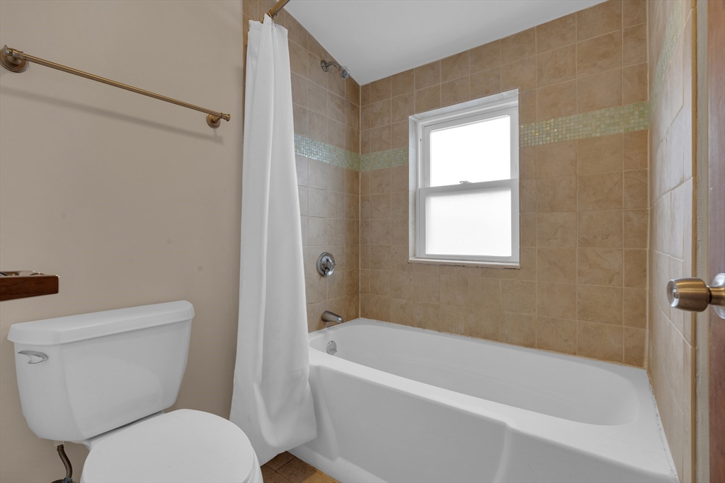 64 Commonwealth Road Watertown, MA 02472 - Photo 21 of 23 a white toilet sitting next to a bath tub
