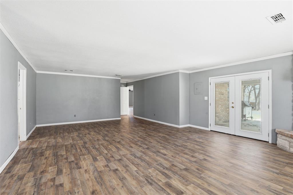 533 Eagles Way Springtown, TX 76082 - Photo 13 of 32 a view of an empty room with wooden floor and a window