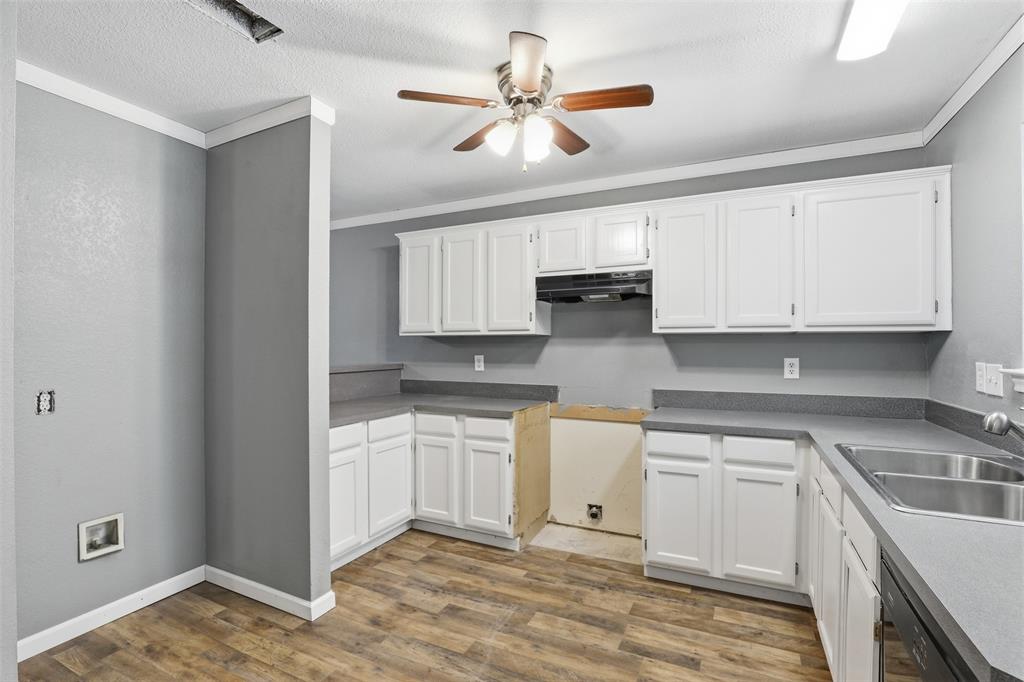 533 Eagles Way Springtown, TX 76082 - Photo 20 of 32 a kitchen with stainless steel appliances granite countertop a sink a stove and white cabinets with wooden floor
