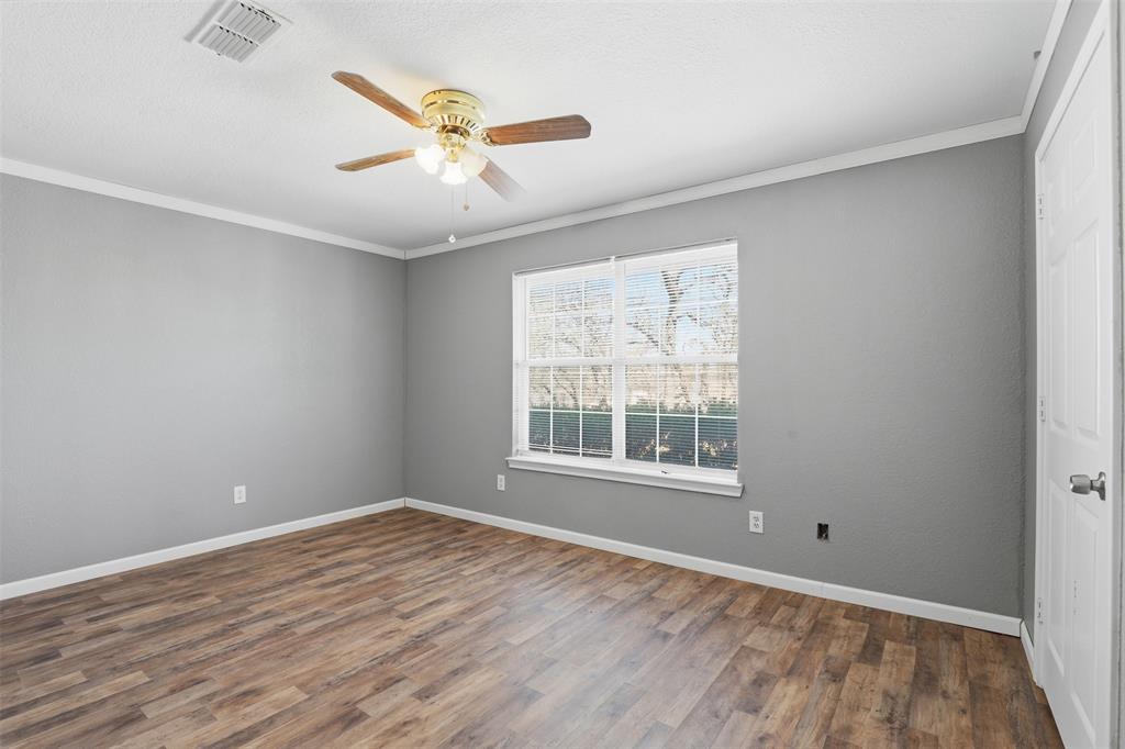 533 Eagles Way Springtown, TX 76082 - Photo 5 of 32 an empty room with wooden floor fan and windows