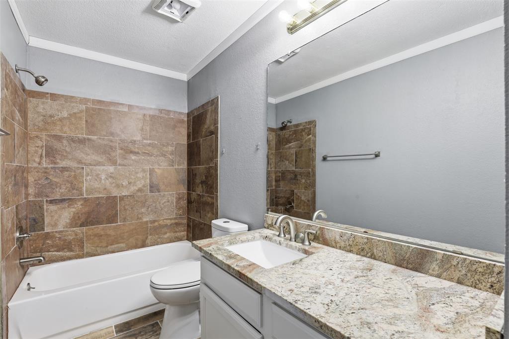 533 Eagles Way Springtown, TX 76082 - Photo 6 of 32 a bathroom with a granite countertop sink a toilet and bathtub