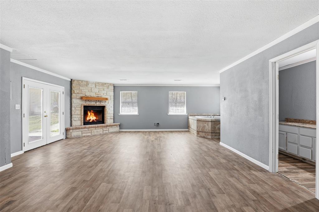 533 Eagles Way Springtown, TX 76082 - Photo 8 of 32 a view of empty room with wooden floor and fireplace