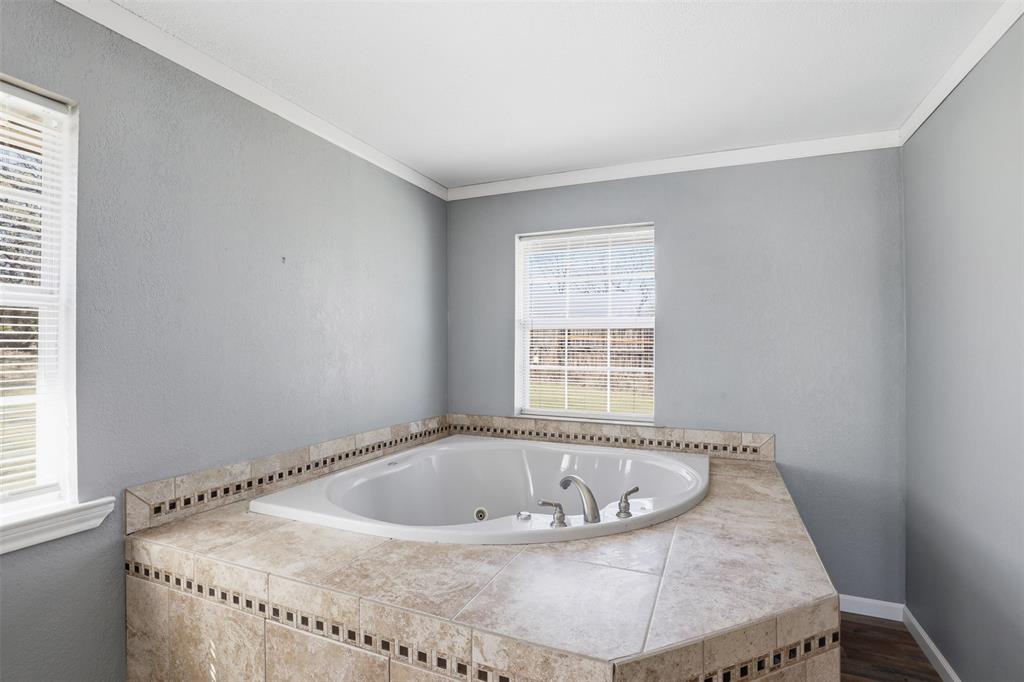 533 Eagles Way Springtown, TX 76082 - Photo 10 of 32 a bath tub sitting in a bathroom next to a window
