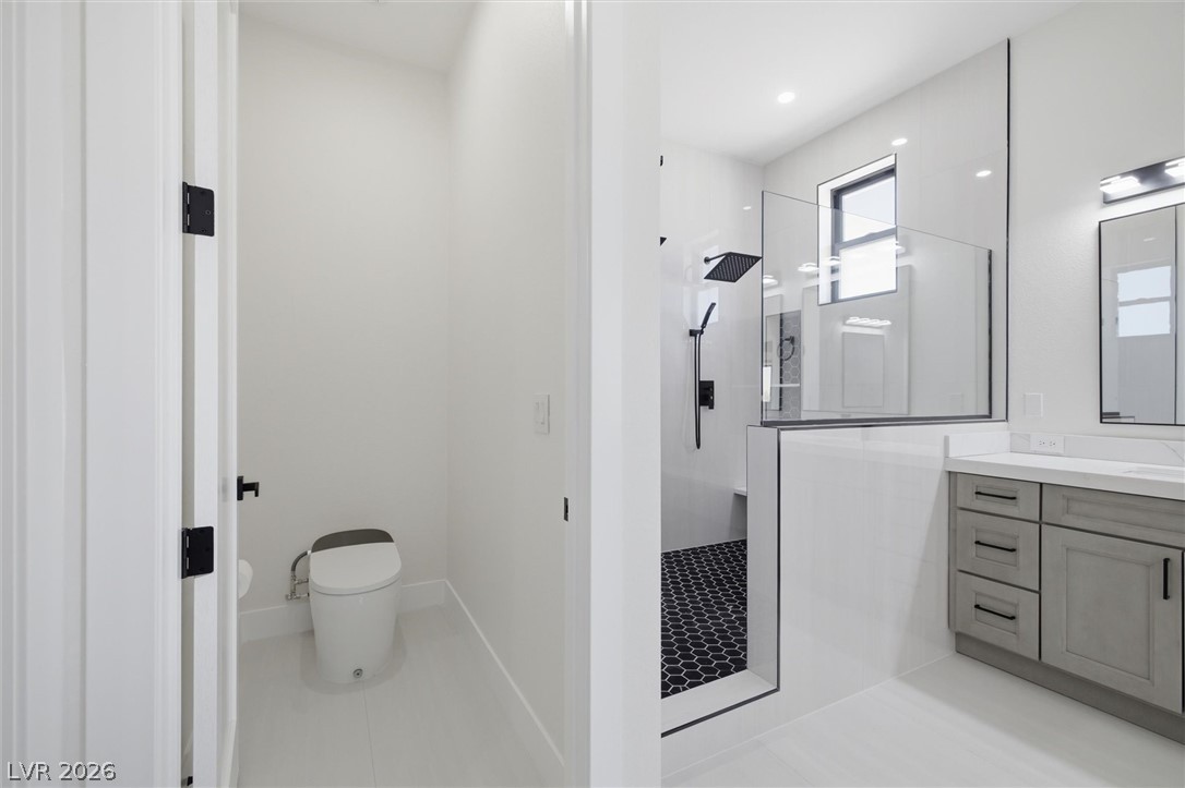 5910 East Kellogg Road Pahrump, NV 89061 - Photo 37 of 58 A well-appointed bath features a private water closet and a spacious walk-in shower with sleek black fixtures.
