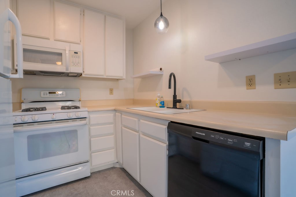1153 Sumner Place, Unit D Santa Maria, CA 93455 - Photo 13 of 33 a kitchen with white cabinets stainless steel appliances and sink
