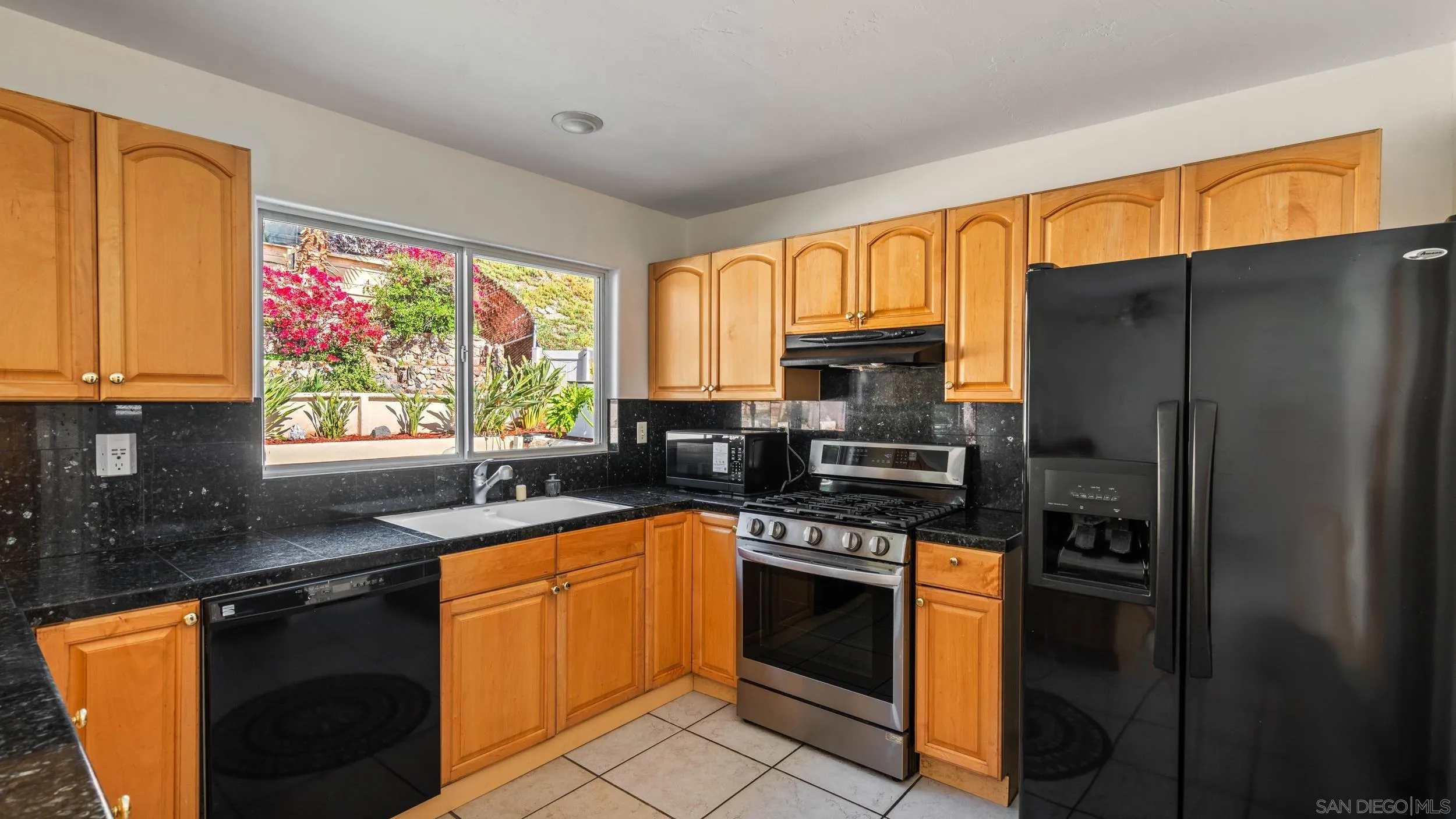 10019 Settle Road Santee, CA 92071 - Photo 14 of 35 a kitchen with stainless steel appliances granite countertop a refrigerator sink stove microwave and cabinets