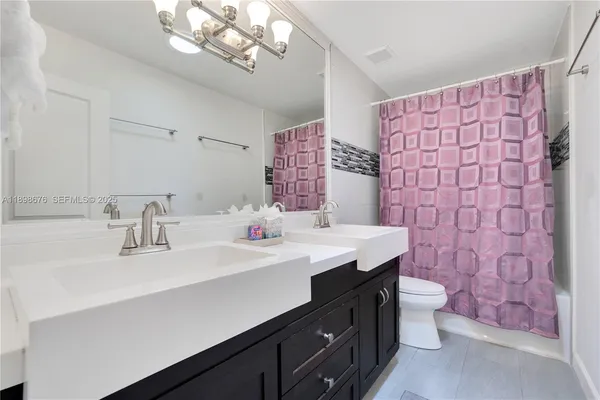 a bathroom with a double vanity sink mirror and toilet