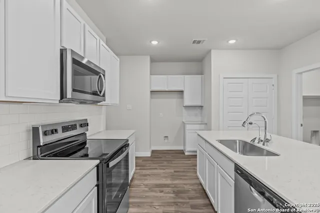 a kitchen with a sink stove and refrigerator