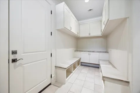 a view of a kitchen with white cabinets and entryway