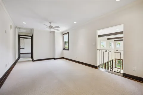 an empty room with windows and a ceiling fan