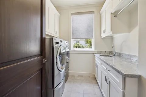 a utility room with cabinets washer and dryer