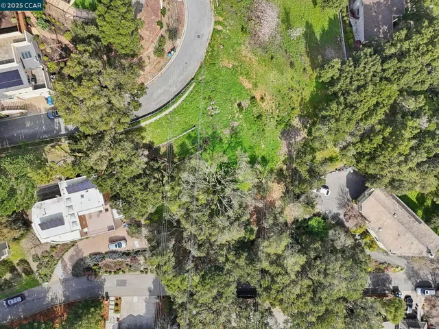 an aerial view of a house with a yard and trees