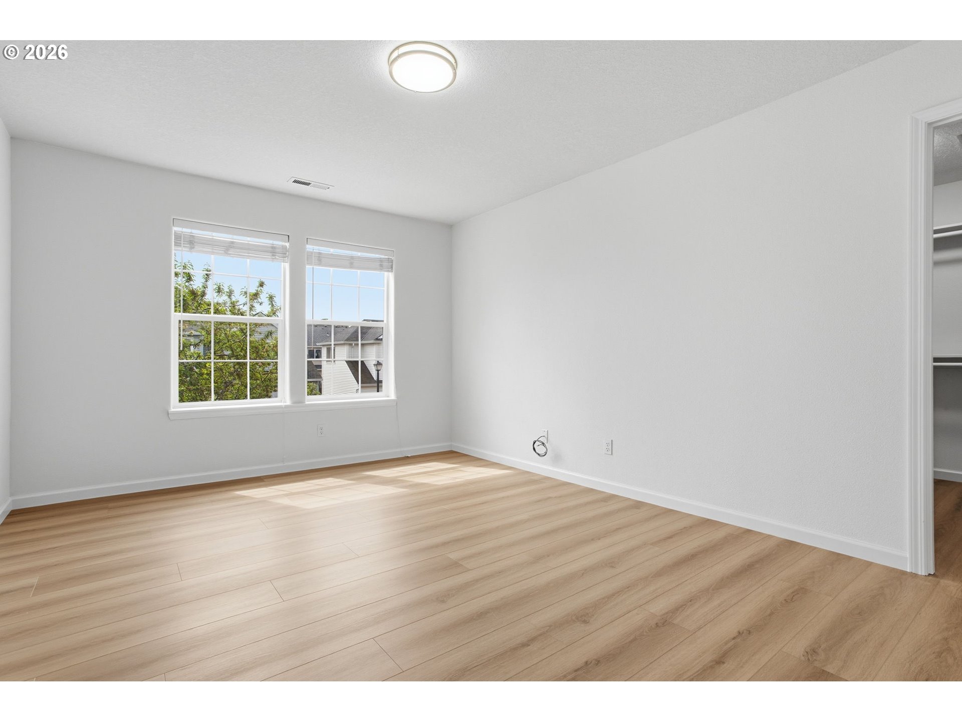 8911 Southwest Gravenstein Lane Tigard, OR 97224 - Photo 21 of 33 a view of an empty room with wooden floor and a window
