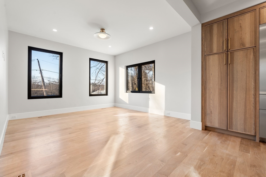 265 Varick Road Newton, MA 02468 - Photo 11 of 32 a view of an empty room with window and wooden floor